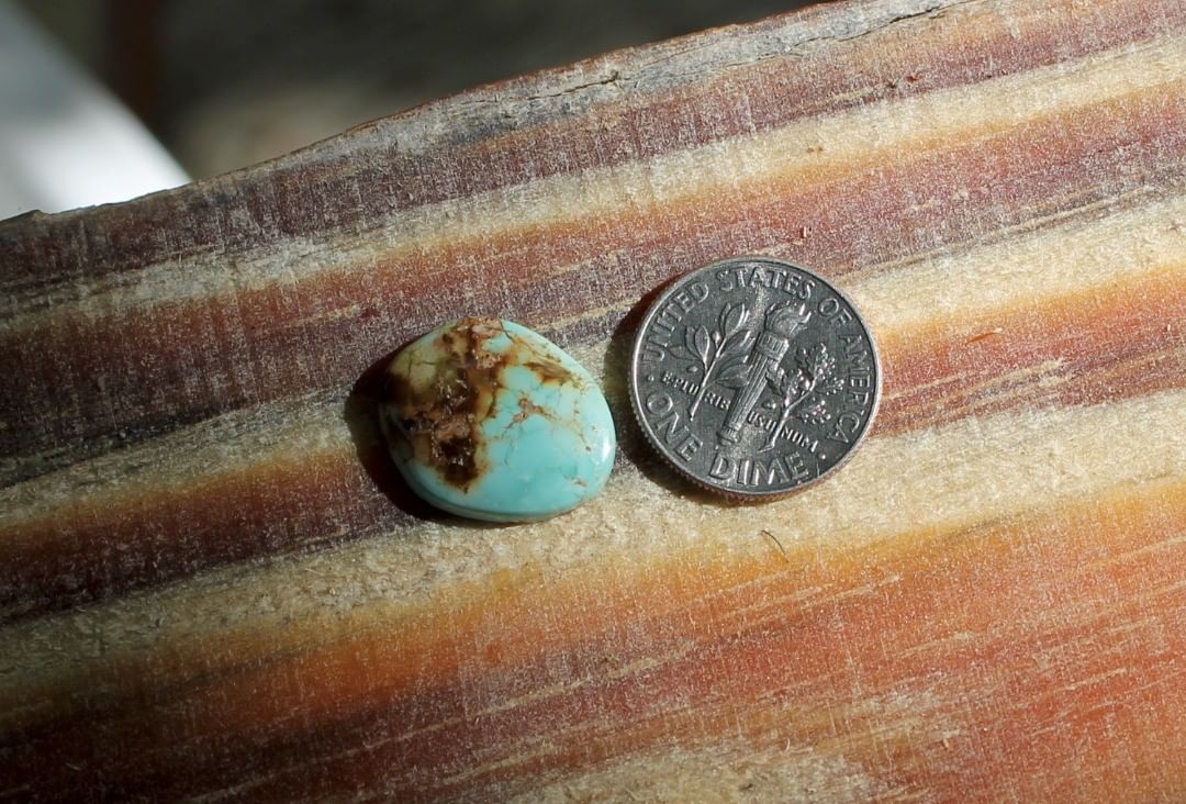 Natural light blue Stone Mountain Turquoise cabochon w/ red inclusions
 $15 for 5.5 carats untreated & un-backed Nevada turquoise.
