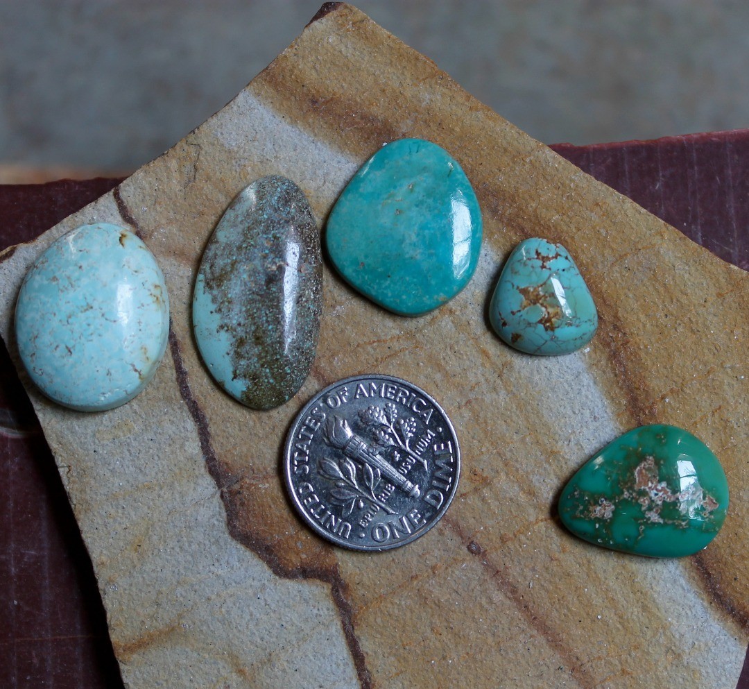 A mix of natural Taubert Hills and one Harcross turquoise(in green) cabochons
